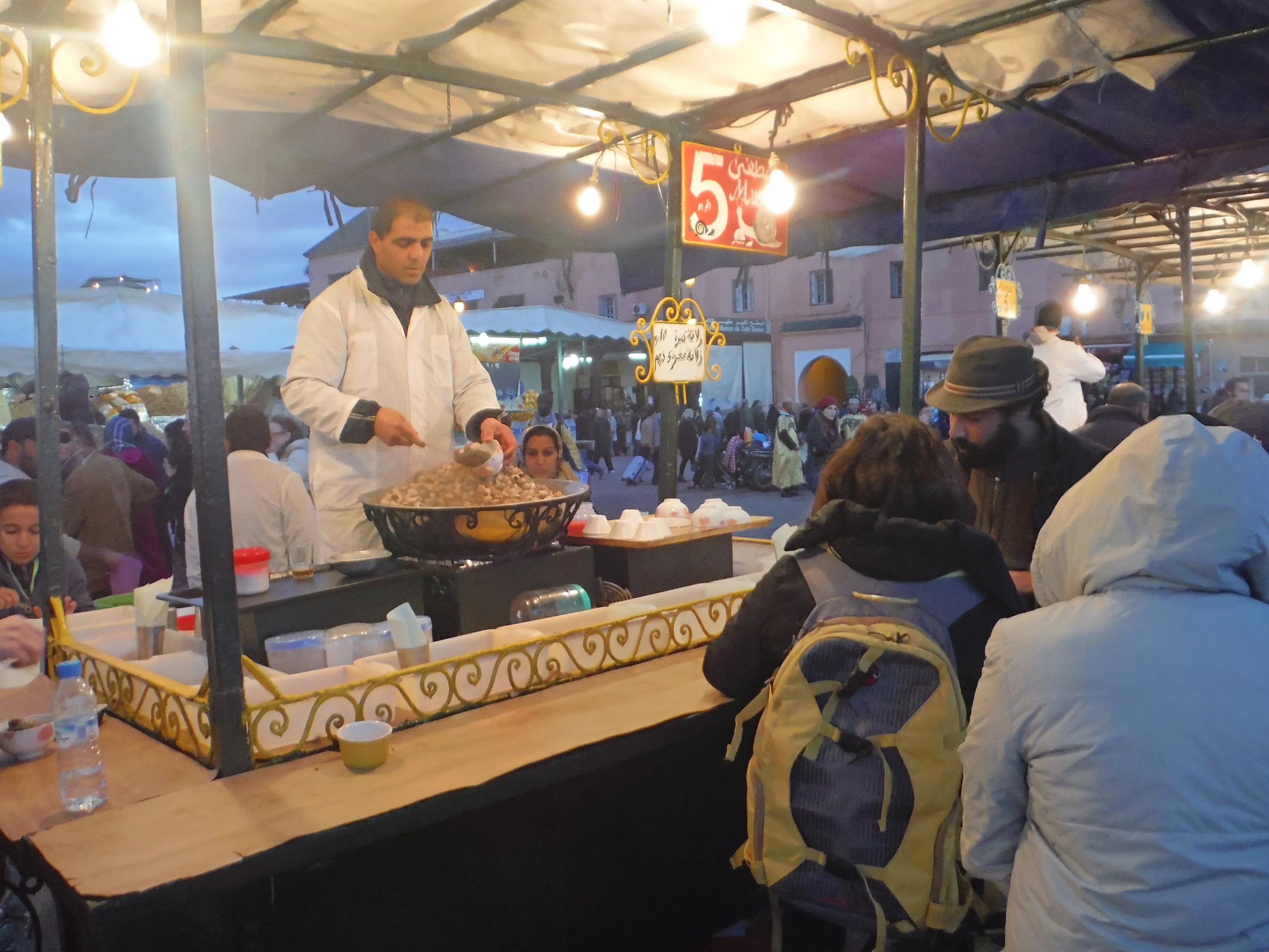 Steaming food stalls and hungry crowds on Jemaa el-Fna square in the evening